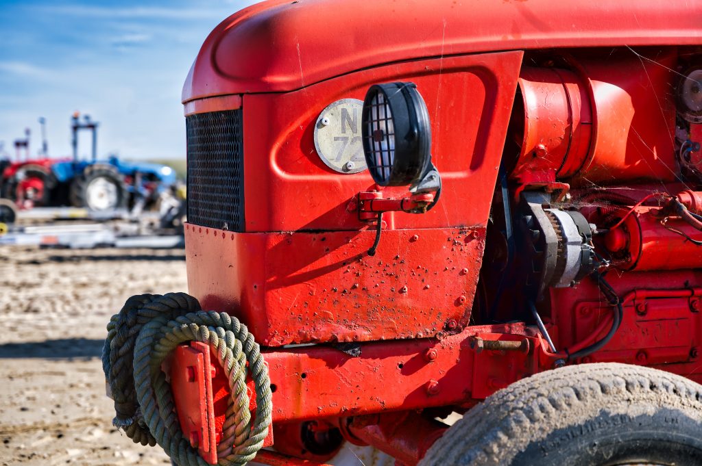 roter Traktor am Strand von Saint-Cômes-de-Fresné in der Normandie